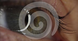 Female eye with gray green pupil slow motion 4k movie