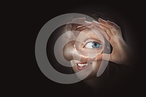 Female eye looking through magnifying glass close up