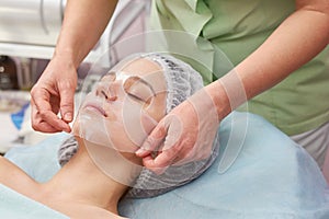 Female face, hands of cosmetician.