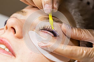 Female face under procedure of eyelashes lamination in beauty salon