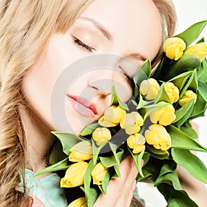 Female Face and Yellow Tulip Flowers. Beauty Portrait