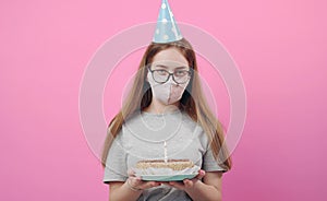 Female with facemask holding cake