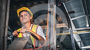 Female factory worker operating forklift in warehouse.