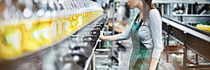 Female factory worker standing near production line