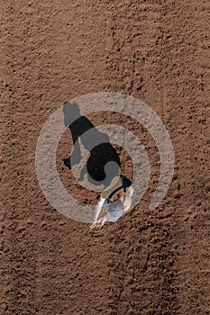 Female farmer examining ploughed field soil, drone photography top view