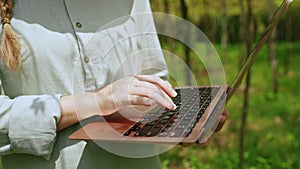 Female farmer with laptop inspecting gourd harvest on vegetable farm, typing on keyboard. Woman agronomist checks