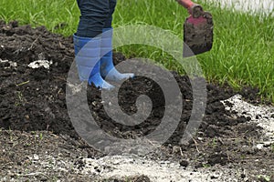 Female Farmer Mixing the Soil and Fertilizers to prepare for Planting in the Garden