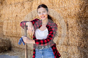 Female farmer posing on hayloft at cow farm
