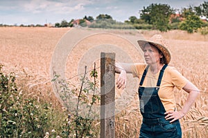 Female farmer posing in ripe barley field just before the harvest