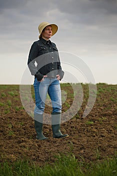 Female Farmer Standing on Fertile Agricultural Farm Land Soil