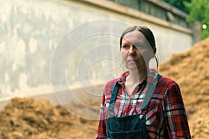 Female farmer standing in front of the horse manure pile
