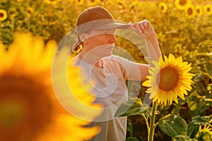 Female farmer with trucker's hat in blooming sunflower field. Agriculture and farming concept