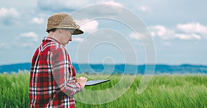 Female farmer using tablet computer in rye crop field