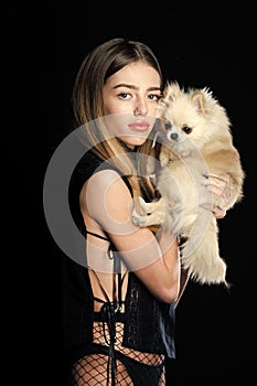 Female fashion, beauty and advertisement concept. Woman with small dog of Pomeranian spitz.