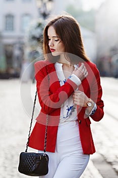 Female fashion concept. Outdoor portrait of a young beautiful confident woman walking on the street. Model wearing