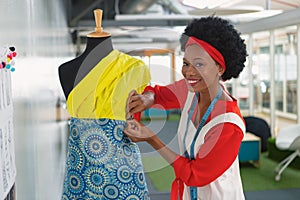 Female fashion designer dressing a mannequin in design studio