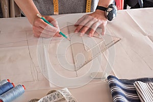 Female fashion designer working with pattern cutting at studio.