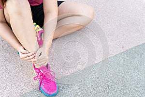 Female fatty runner athlete leg injury and pain. Hands grab painful leg while running in the park