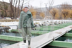 Female feeding fish on sturgeon farm