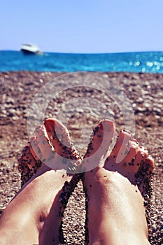 Female feet against the sea
