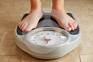 Female feet on a bathroom scale