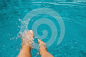 Female feet in blue water pool