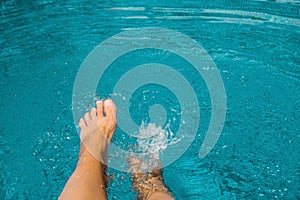 Female feet in blue water pool