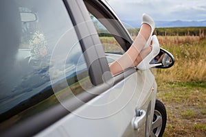 Female feet in a car window