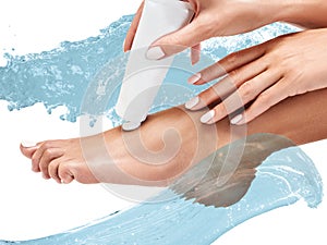 Female feet with cream among water splashes.