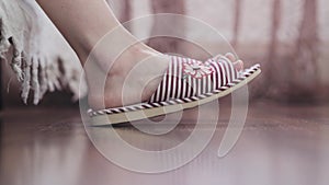 Female feet getting out of bed, close-up.