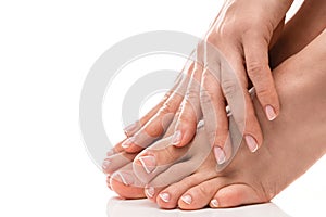 Female feet and hands with soft skin, french manicure and pedicure on white background