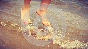 Female feet jump on beach.