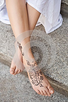 Female feet painted with henna