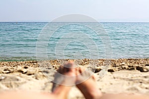 Female feet, sandy beach and sea in the background. Picture with soft focus and place for your text. summer concept. Enjoying the