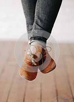 Female feet shoes laces not touching floor