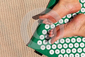 Female feet standing on acupressure mat. Self acupuncture massage