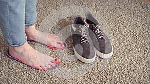 Female feet standing on the orthotics near sneakers