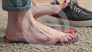 Female feet standing on the orthotics near sneakers slow mo