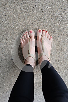 Female feet wearing slippers or flip-flop outdoor red nail