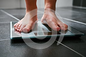 Female feet with weight scale in the bathroom