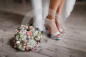 Female feet in white wedding sandals