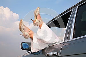 Female feet in window of car