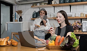 Female and female or LGBT couples are happily cooking bread together with happy smiling face in kitchen at home