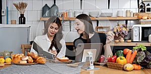 Female and female or LGBT couples are happily cooking bread together with happy smiling face in kitchen at home