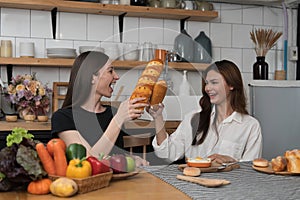 Female and female or LGBT couples are happily cooking bread together with happy smiling face in kitchen at home