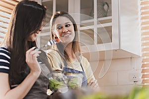 Female and female or LGBT couples are happily cooking bread together in the home kitchen