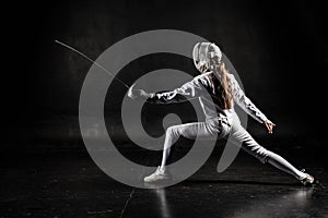 Female fencer on black background