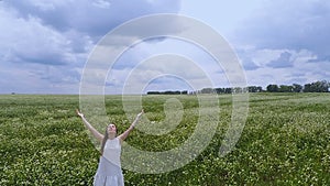 Female in fields rising hands to sky, oneness with nature prayer to God ask help