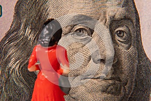 A female figure examining United States paper currency with the concepts of obtaining wealth