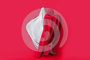 Female figures in fluttering in the wind fabrics. Red and white silhouette on a red background in the Studio. Minimalism. Concept